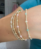 Three beaded bracelets on a wrist with a blurred background