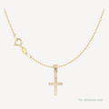 Gold cross pendant necklace on a white background