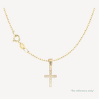 Gold cross pendant necklace on a white background