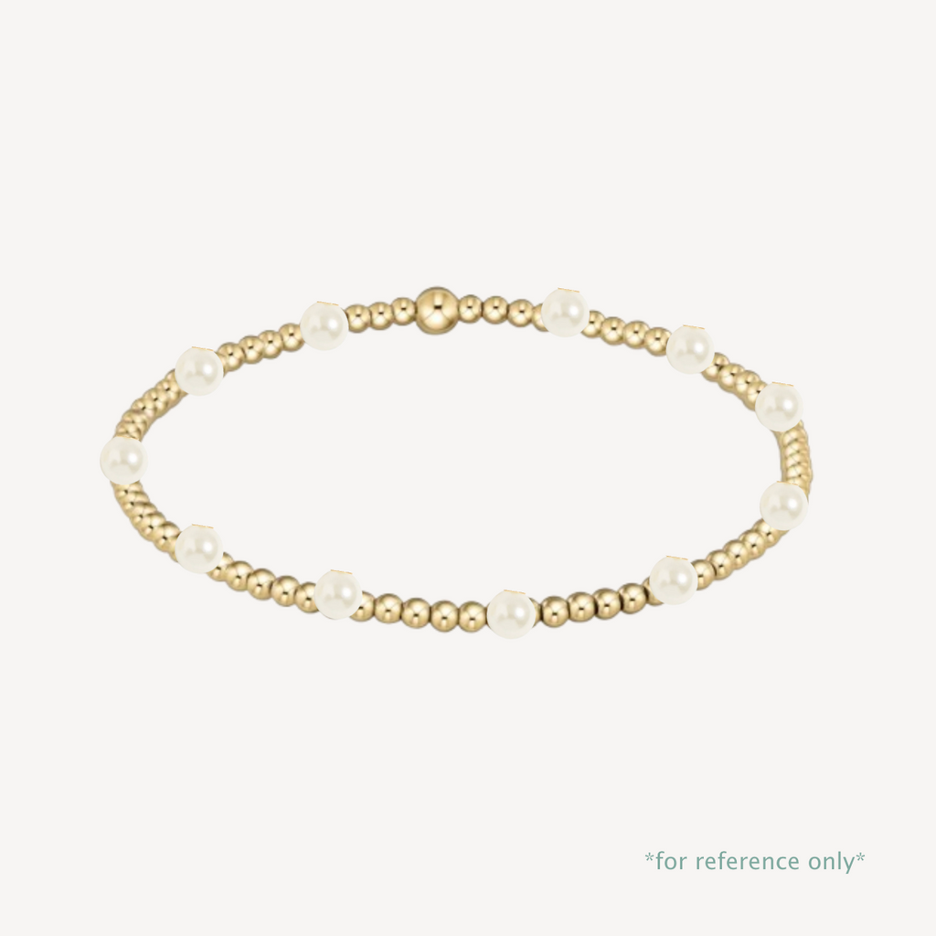 Gold and pearl bracelet on a white background
