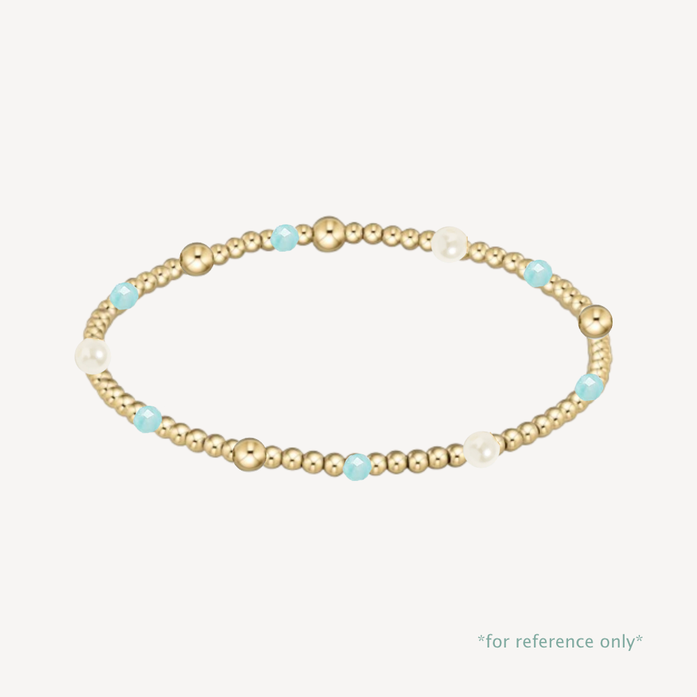 Gold beaded bracelet with pearls and turquoise beads on a white background