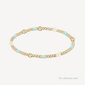 Gold beaded bracelet with pearls and turquoise beads on a white background